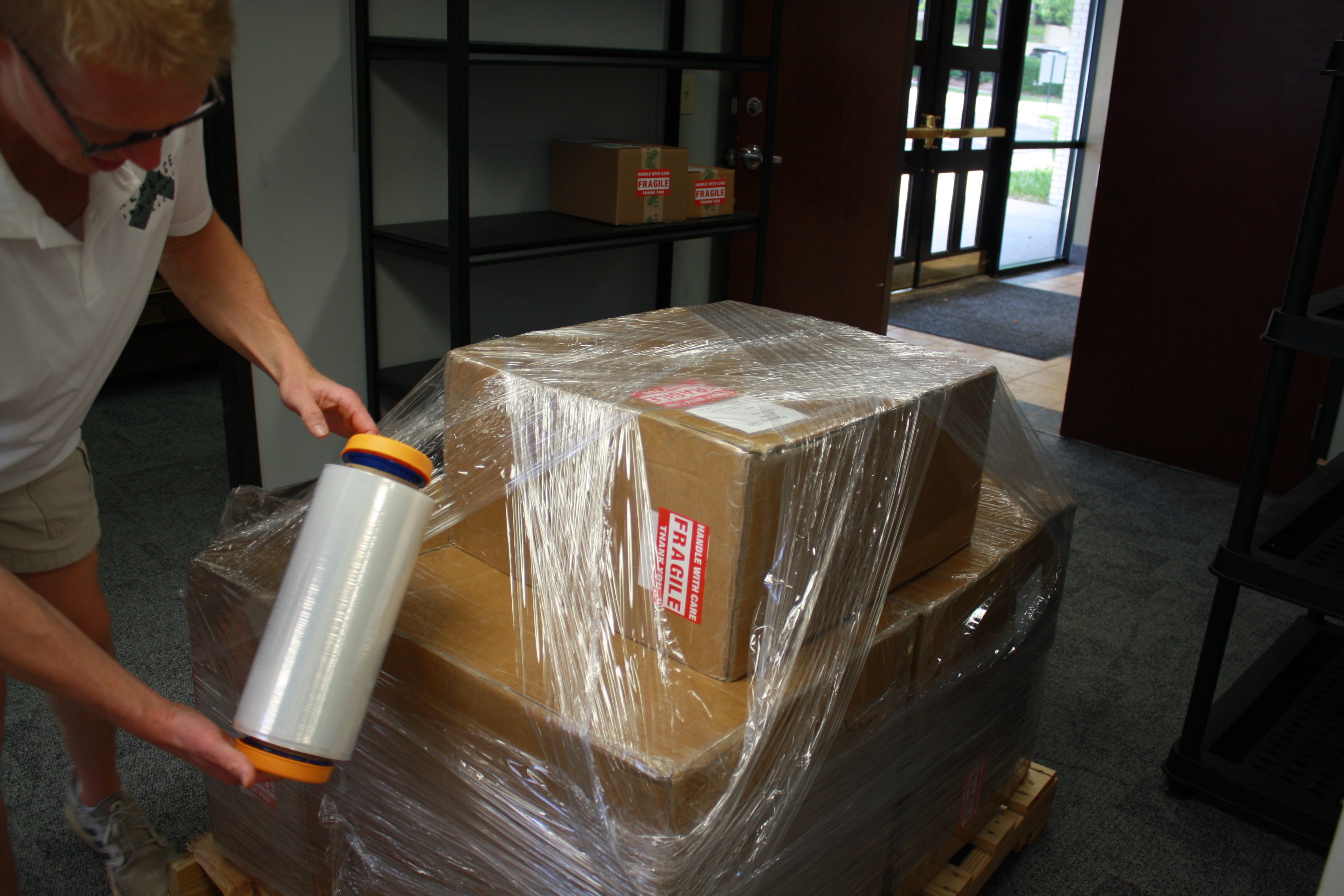 A Replace Industrial team member wrapping a shipment in protective packaging